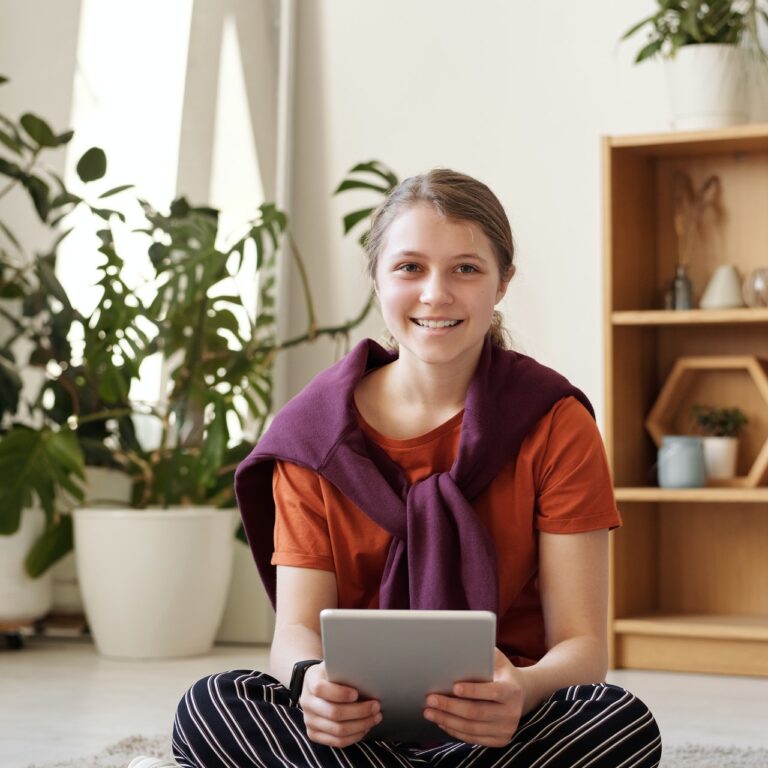girl-smiling-while-holding-silver-ipad-4144453